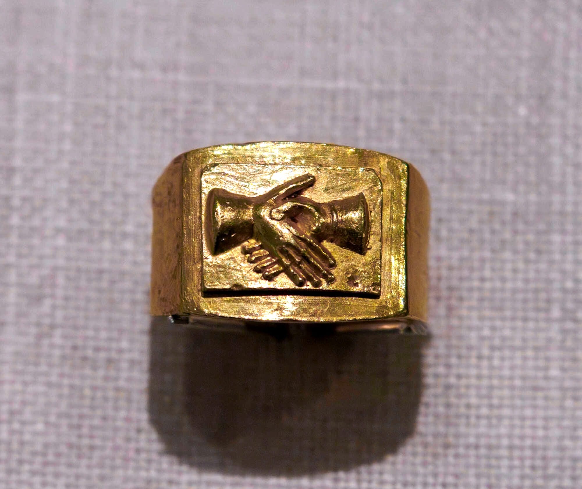 The symbol of the clasped hands was known in ancient Roman culture by the Latin term ‘dextrarum iunctio’. The depiction of the dextrarum iunctio was highly popular in Roman art. In the Roman world, the right hand was sacred to Fides, the deity of fidelity. The clasping of the right hand was a solemn gesture of mutual fidelity and loyalty at the conclusion of an agreement or contract, the taking of an oath of allegiance, or reception in the mysteries, whose initiates were referred to as syndexioi, "joined by the right hand"