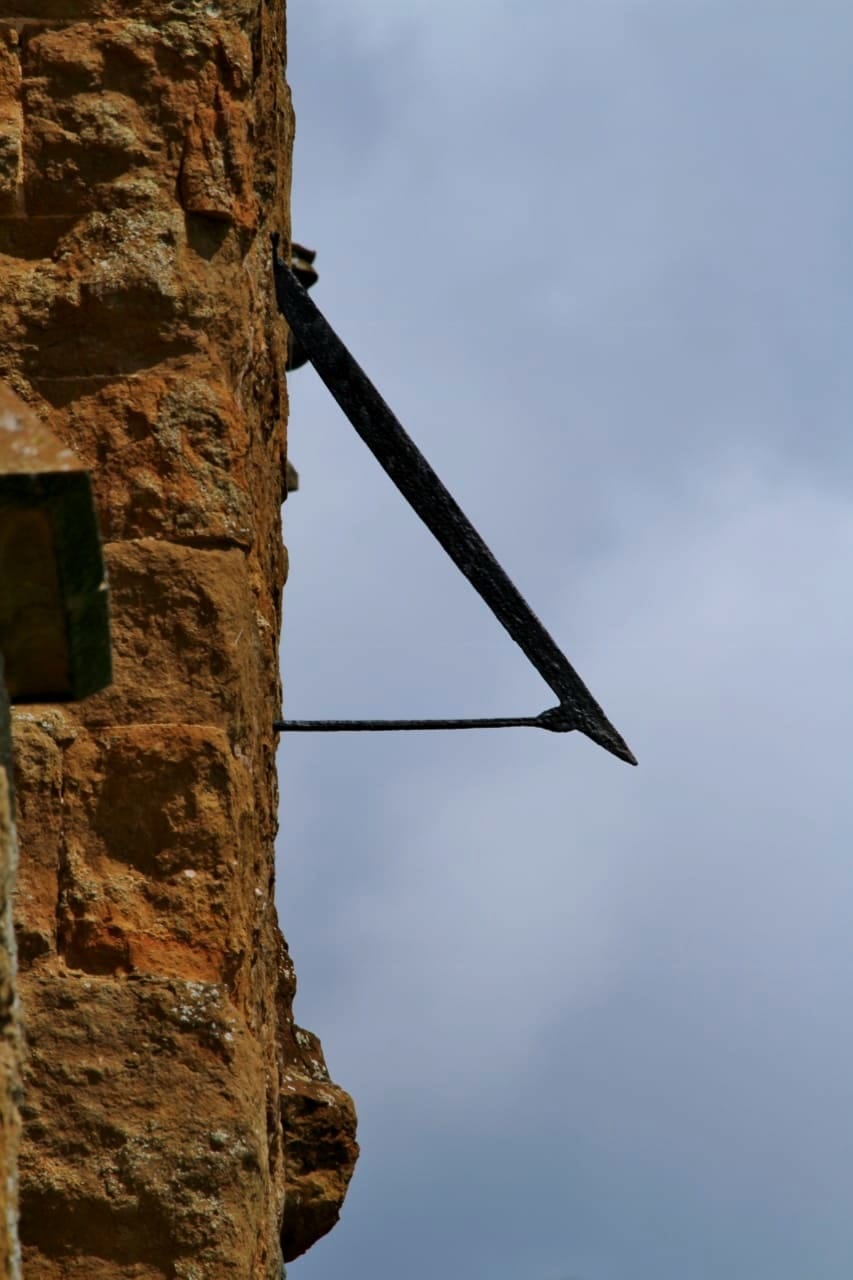 Gnomon of a former sundial on the west tower of St Peter's parish church, Kineton, Warwickshire, seen from the west