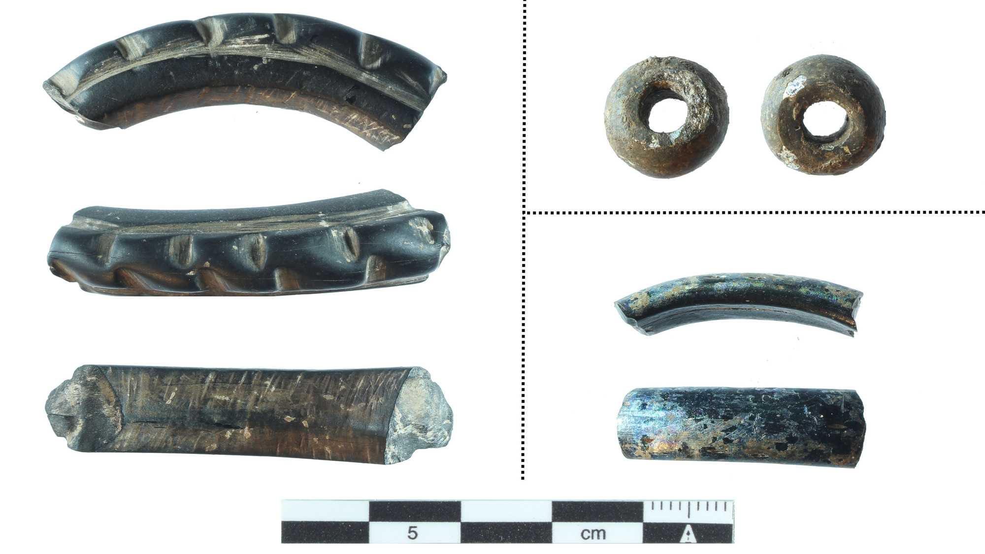 Personal ornaments recovered during the 2026 excavation. 1) jet bracelet; 2) glassy necklace bead; 5) fragments of glassy bracelets; 5) bronze earring