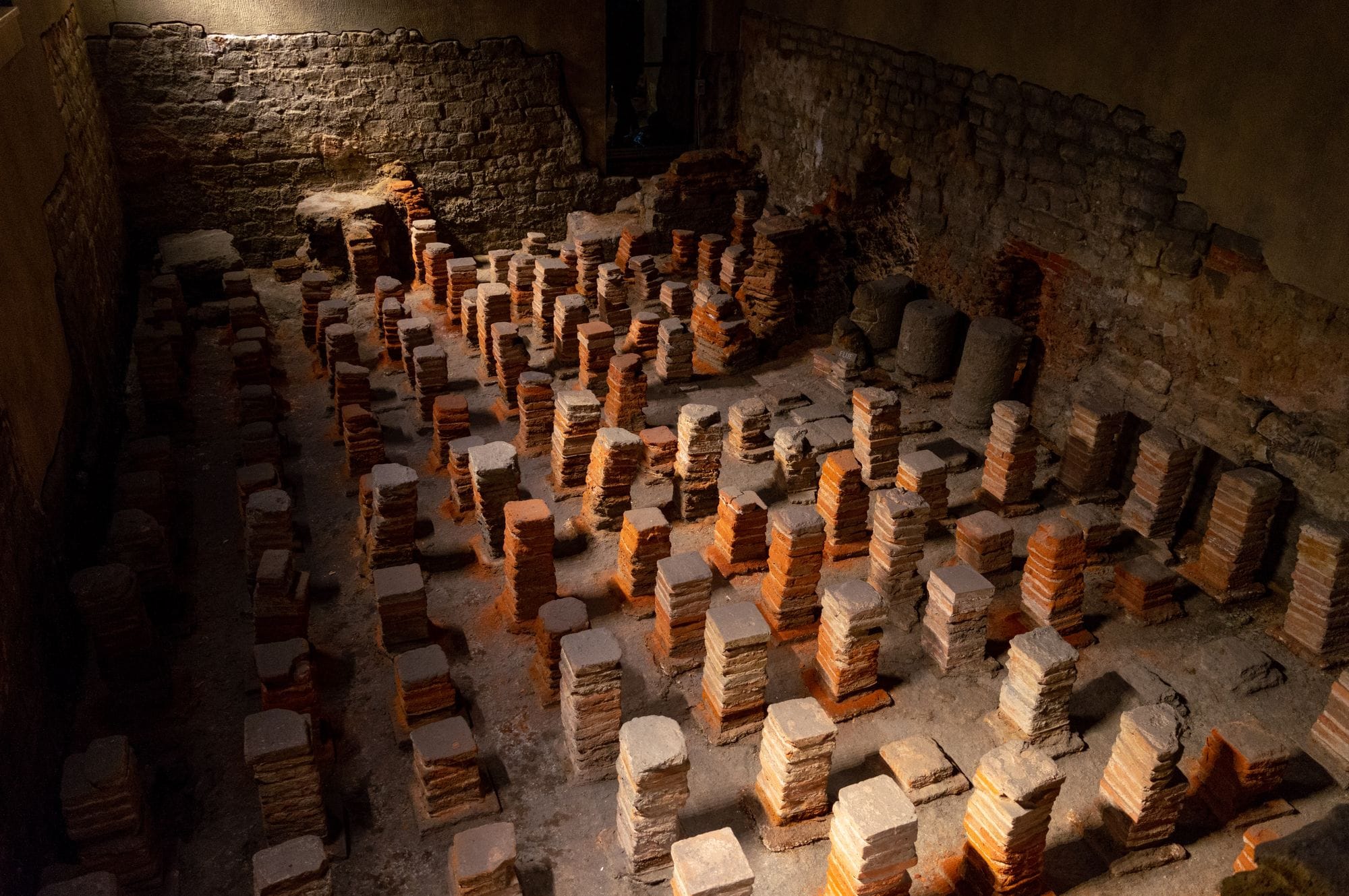 Rows of short brick pillars once supporting a heated floor in the west baths at Bath.