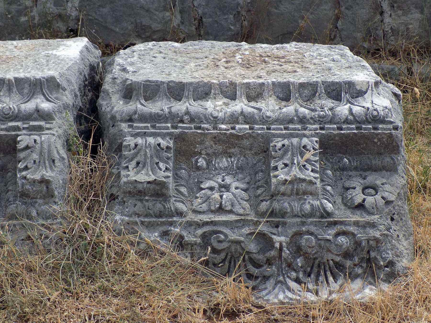 Rectangular carved stone block with repeating floral panels and moulding at the Doclea ruins.