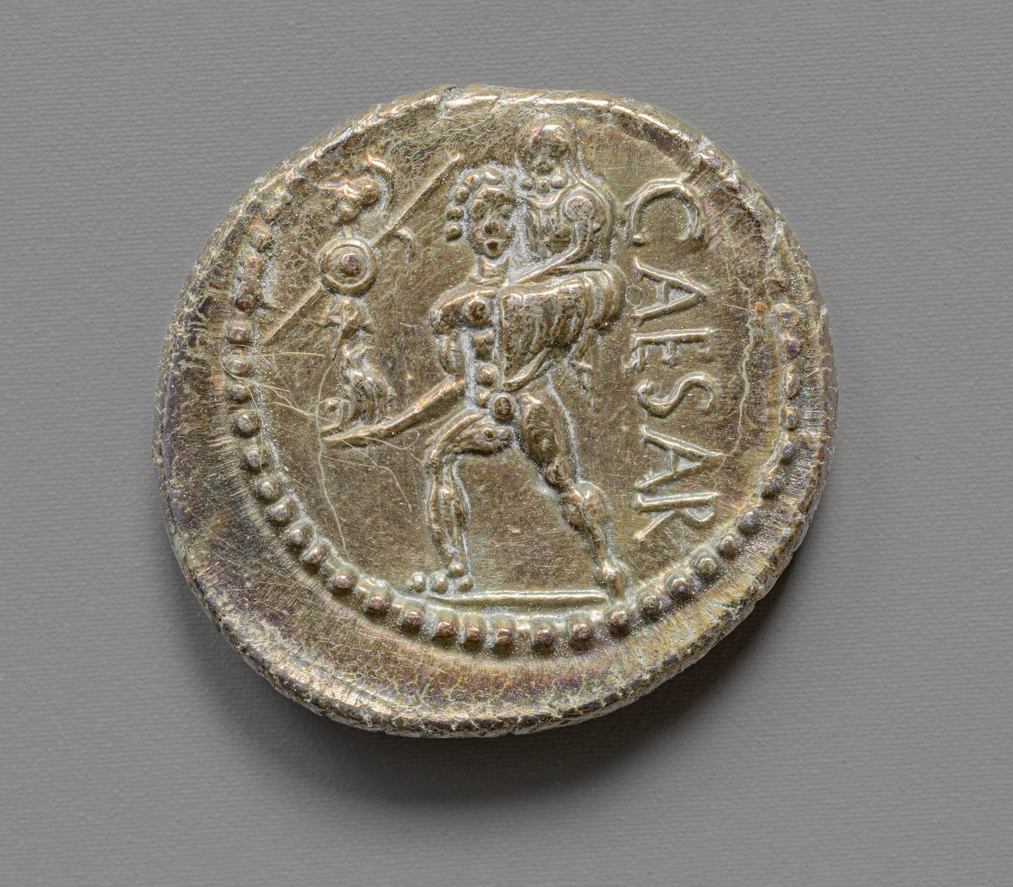Reverse of Julius Caesar’s silver denarius showing Aeneas carrying Anchises, with the inscription CAESAR to the right.