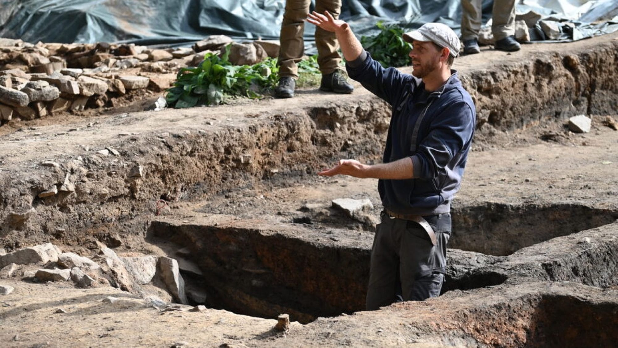 Manuel Pieper indicating excavated burn traces in a Roman workshop at Kapersburg.