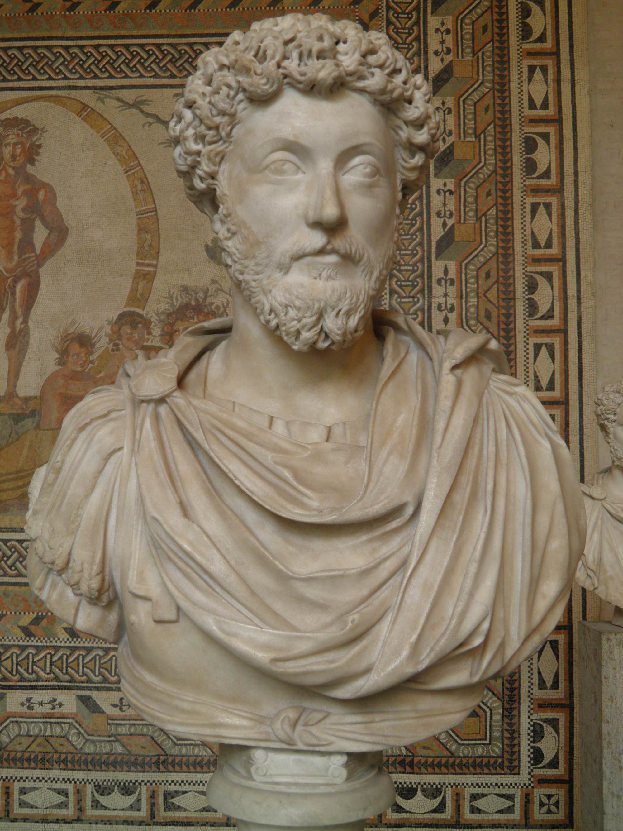 Bust of Marcus Aurelius with curly hair, a beard and a draped cloak, displayed at the Glyptothek in Munich.