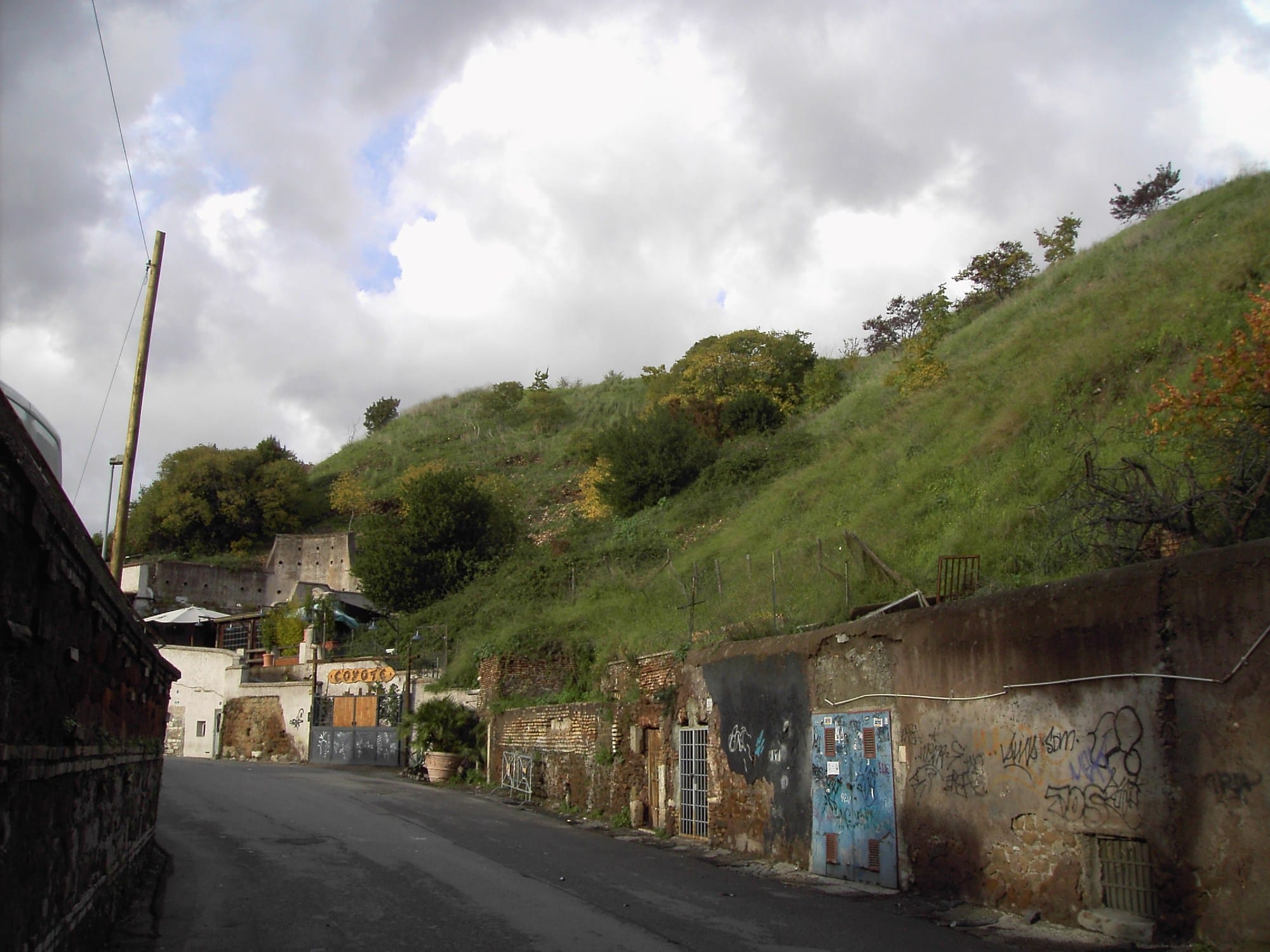 Monte Testaccio’s grass-covered artificial hillside rising above a street and buildings in Rome.