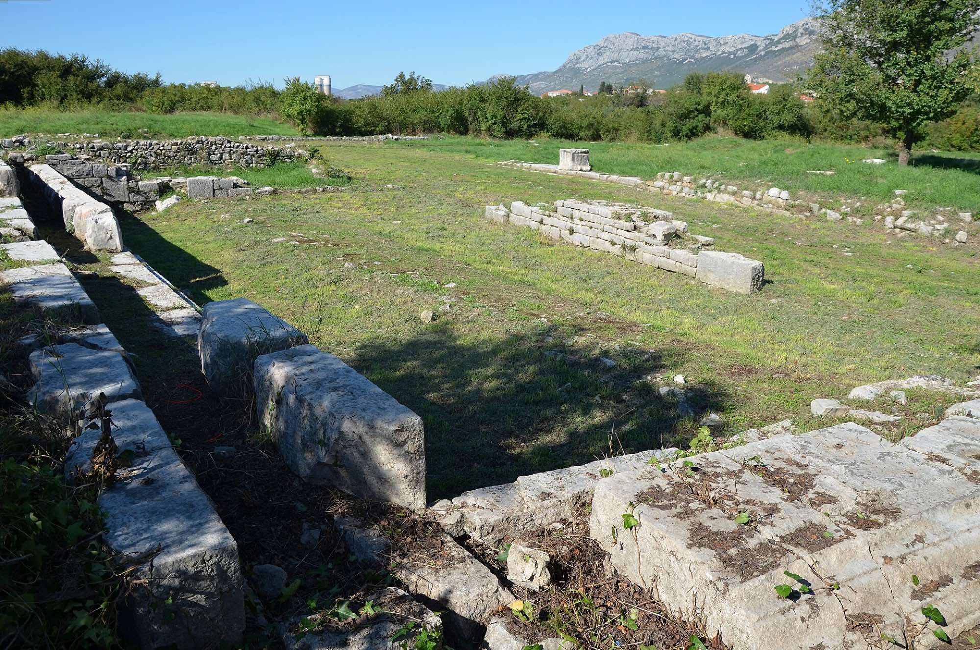 The surviving stone foundations of Salona’s Roman forum, with hills behind the site.
