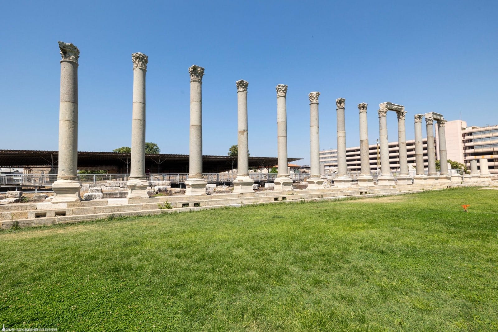 A row of surviving stone columns at Smyrna’s agora, with modern İzmir buildings behind.