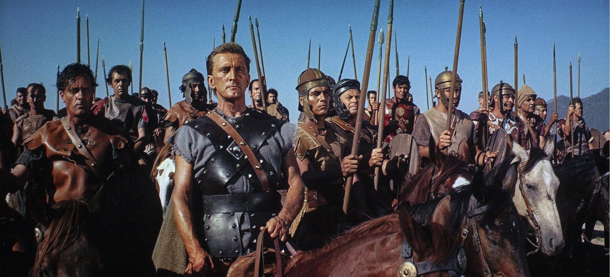 Kirk Douglas as Spartacus on horseback, with armed rebels behind him, in a colour frame from the 1960 film.
