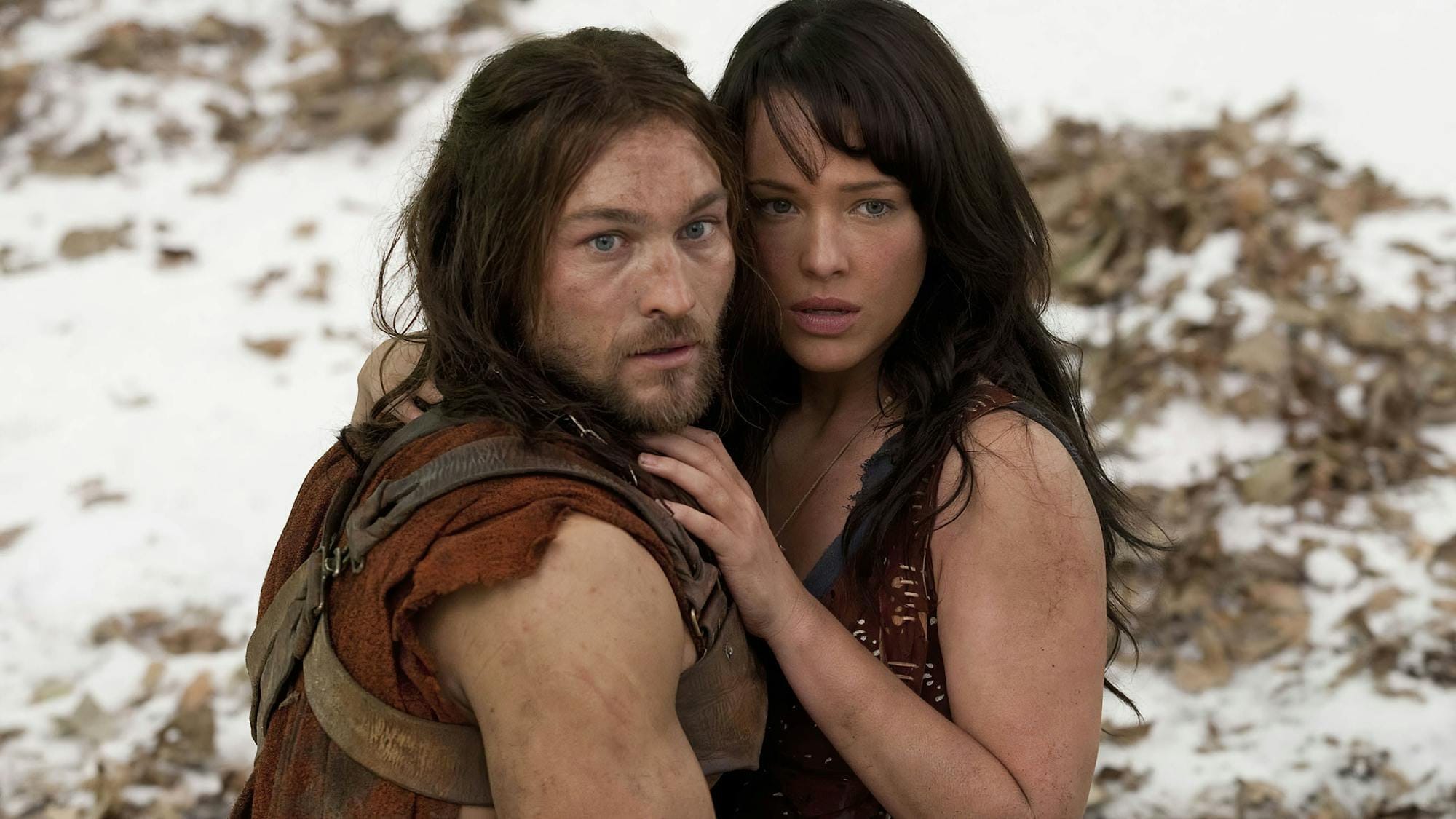 Andy Whitfield’s Spartacus holding a dark-haired woman in a snowy scene.