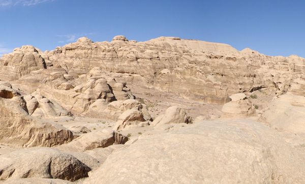 Sunlit sandstone ridges and pale rocky desert near Petra, Jordan.
