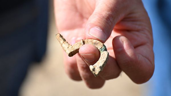 A hand holds the small late antique brooch recovered near the Roman temple at Kapersburg.