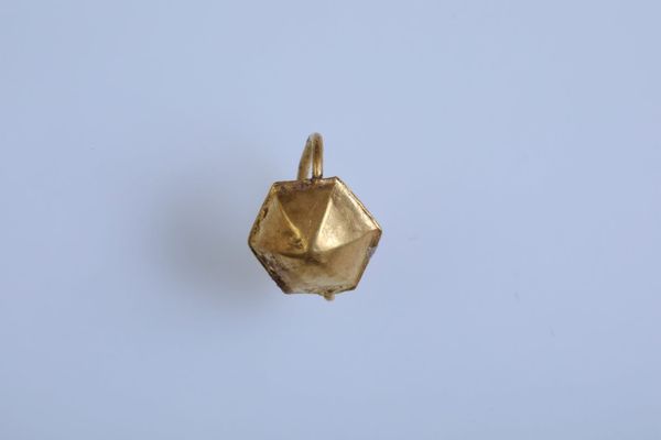 Faceted gold earring with a loop, recovered beside the child’s left ear in Stara Zagora.