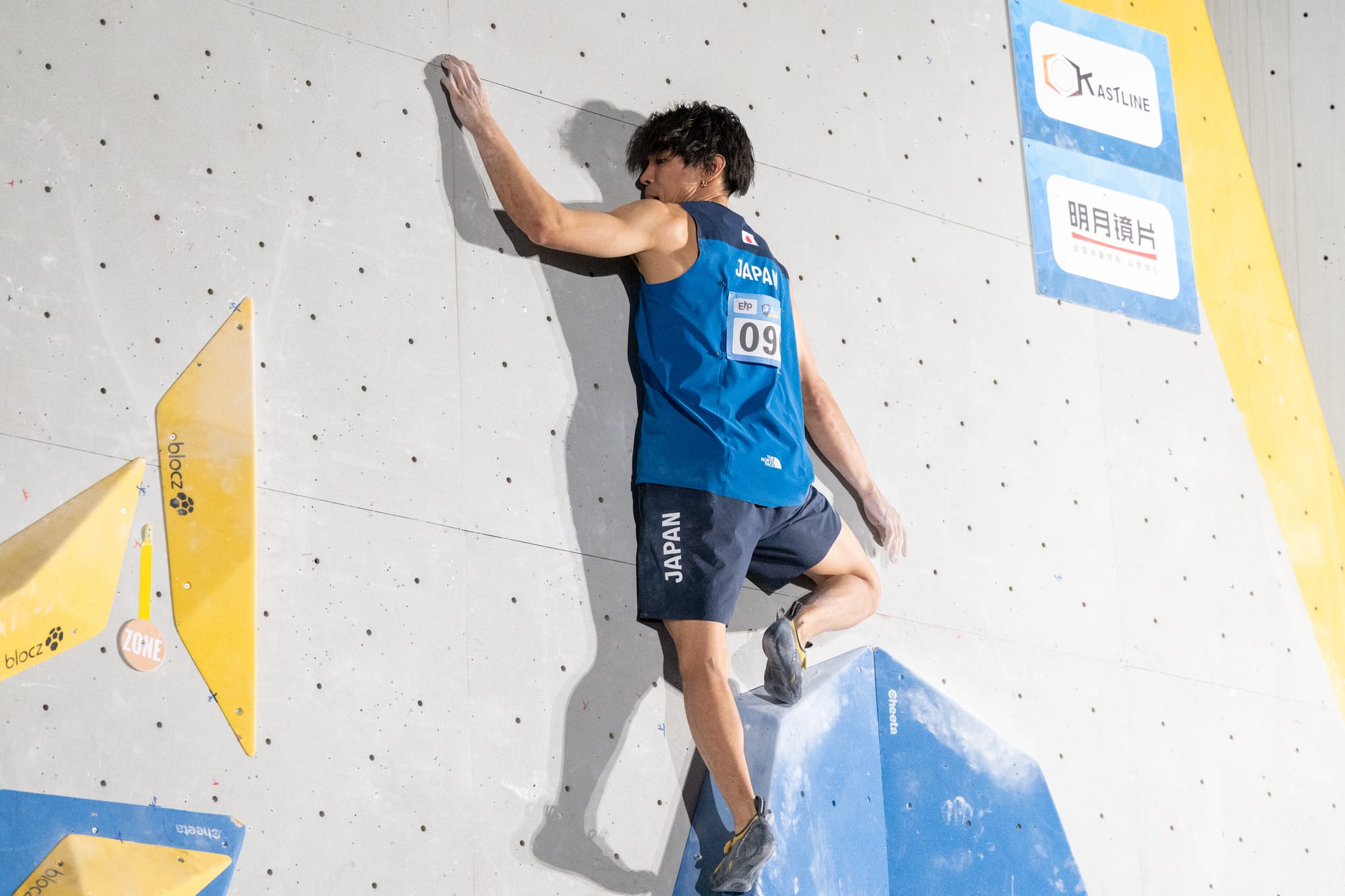 Tomoa Narasaki balancing up on the start volumes before leaning over towards the zone.