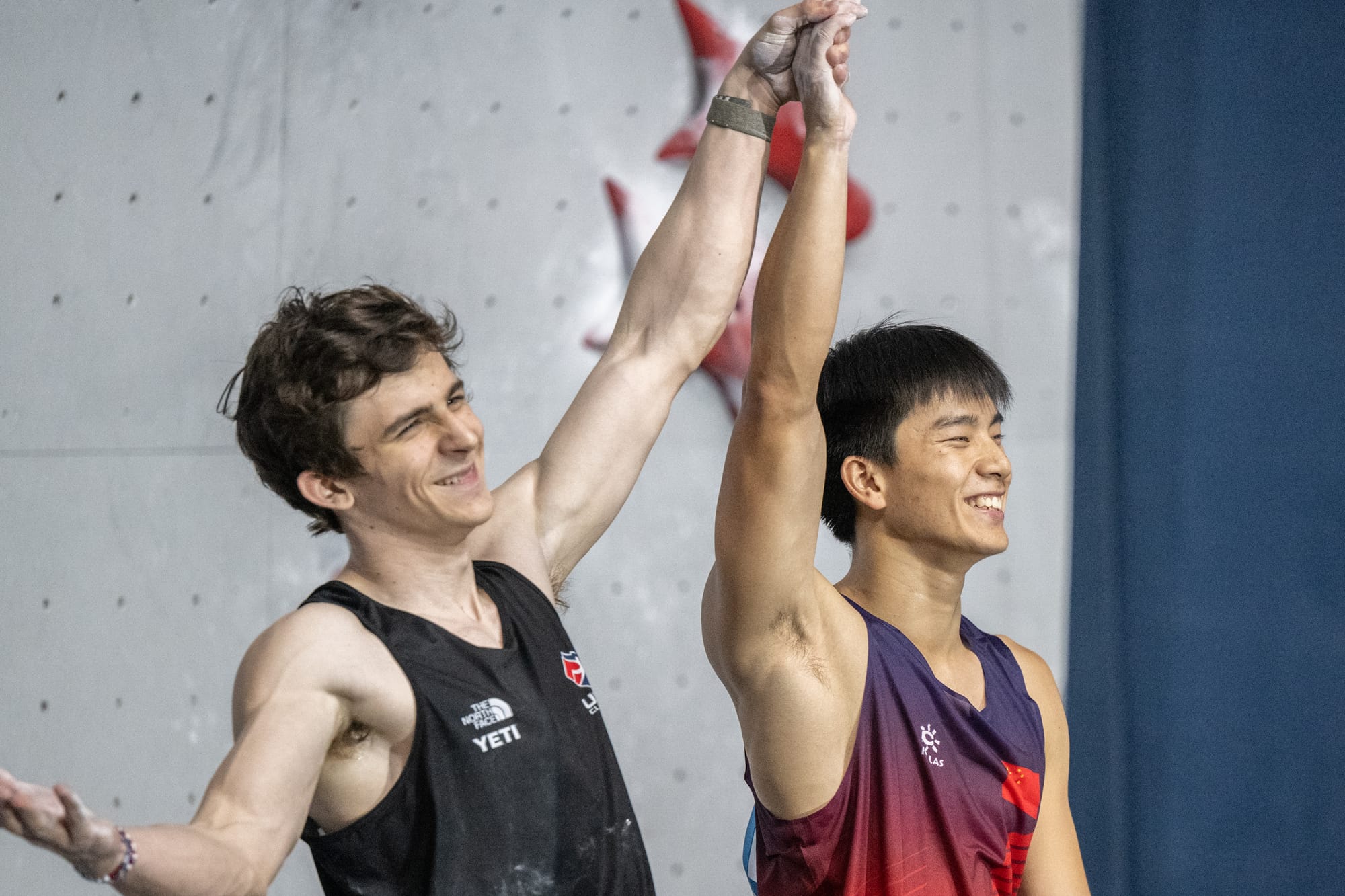 Sam Watson holding up Peng Wu's hands after Wu wins.