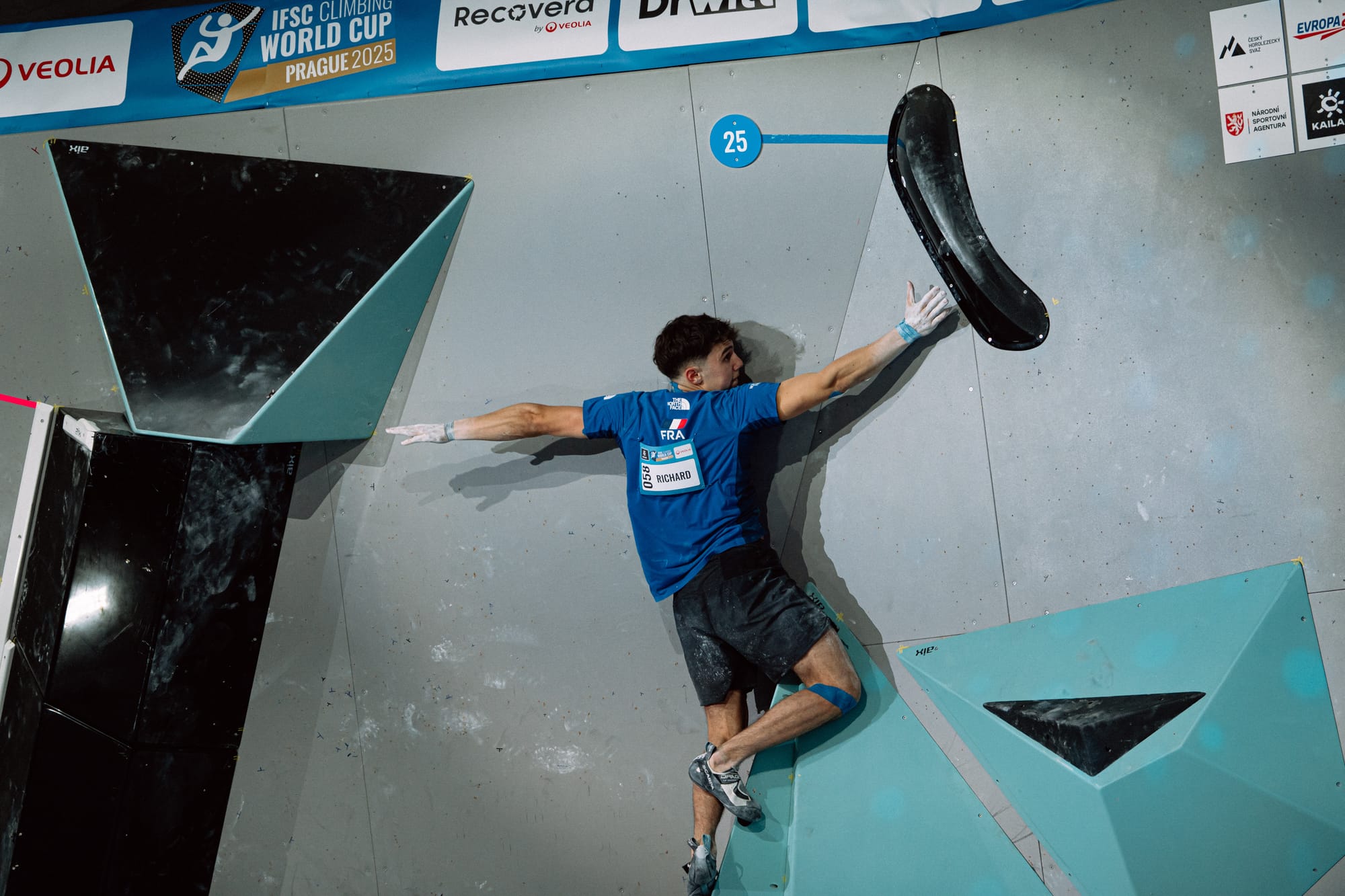 Samuel Richard reaching for the top hold of the last boulder of the final