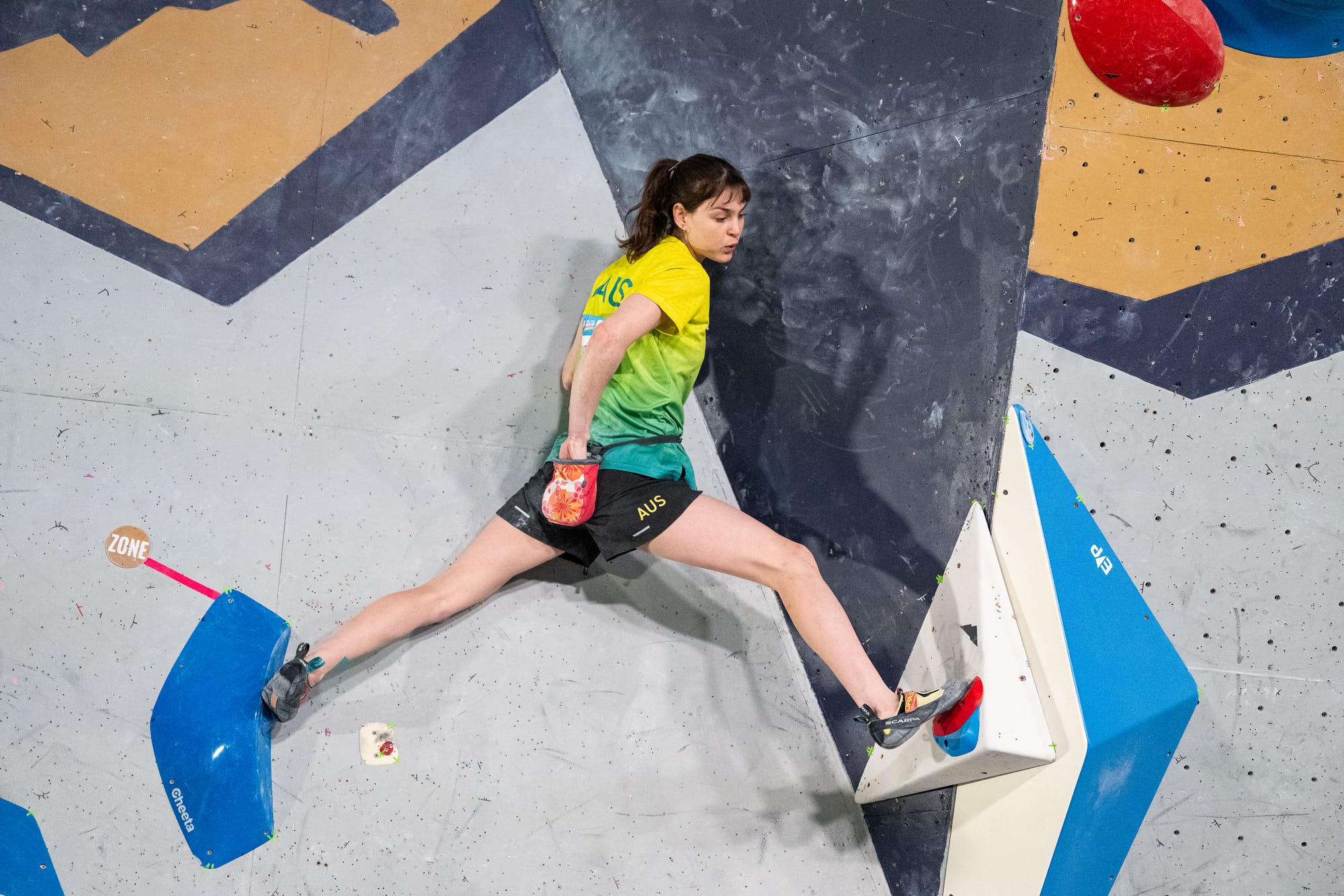 Oceania Mackenzie chalking up in the corner before finishing the final moves.