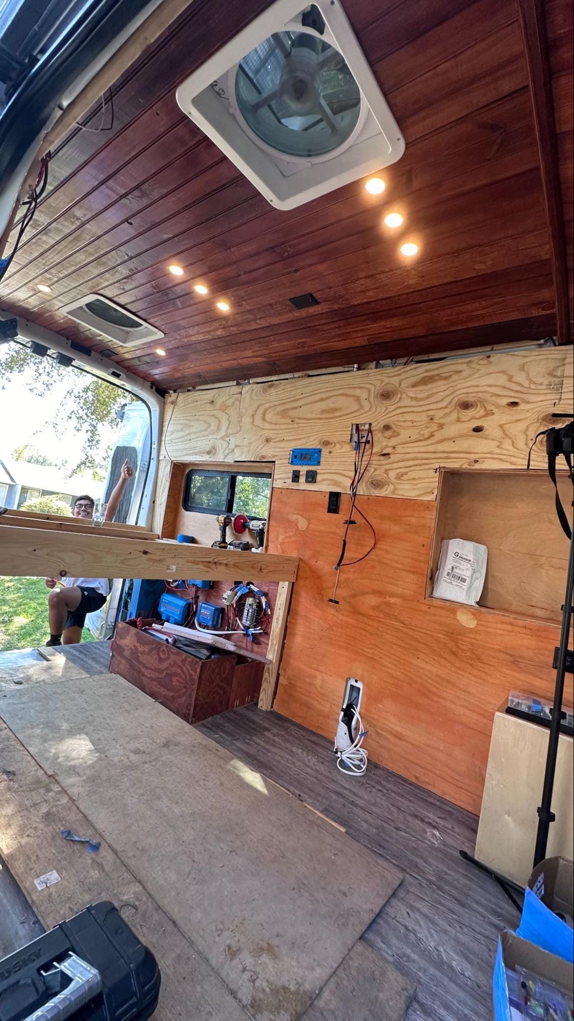 Partially converted campervan with wooden frames and electrical system