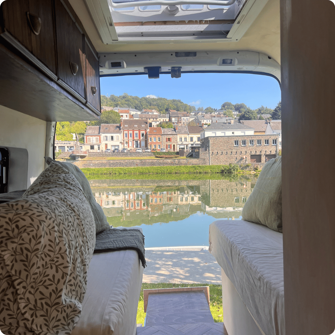 View of an old European stone village near the water from the back of a campervan