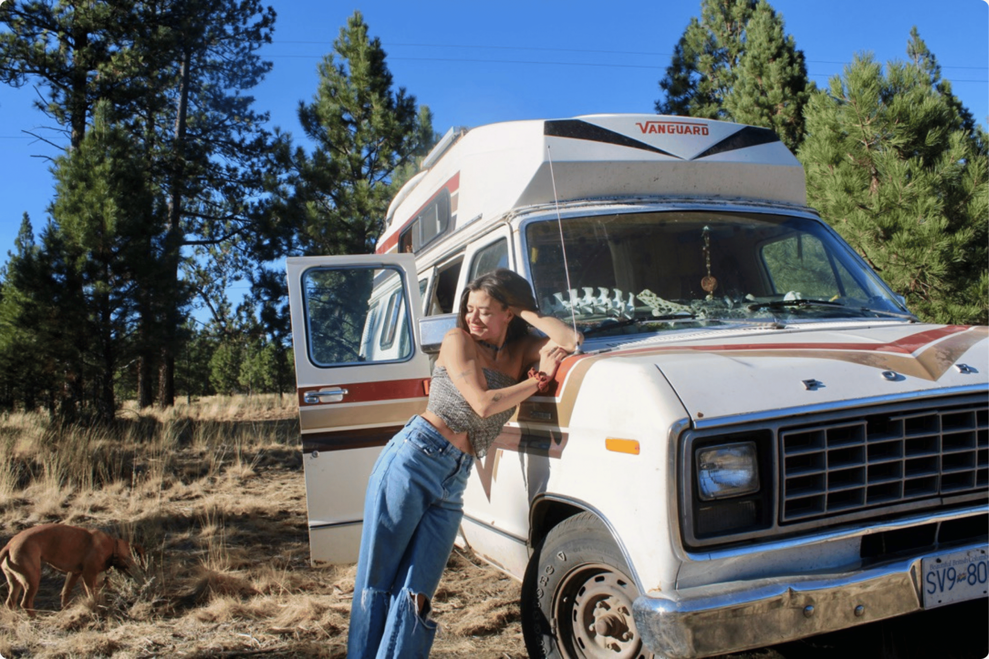 Woman posing on the hood of a retro styled campervan