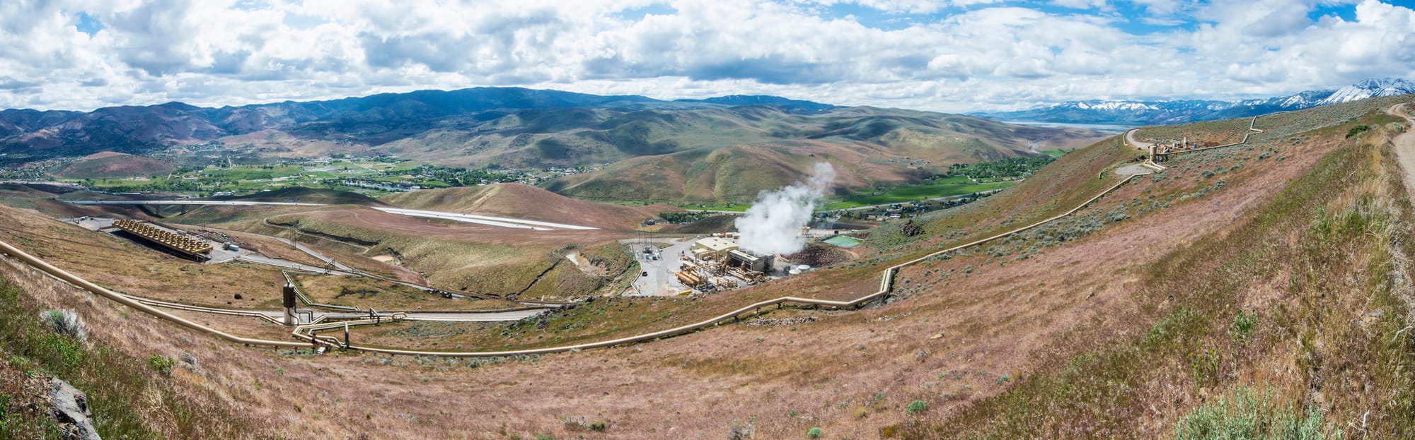 A wide view of geothermal buildings and long pipelines across the hills around the Galena II plant in Nevada.