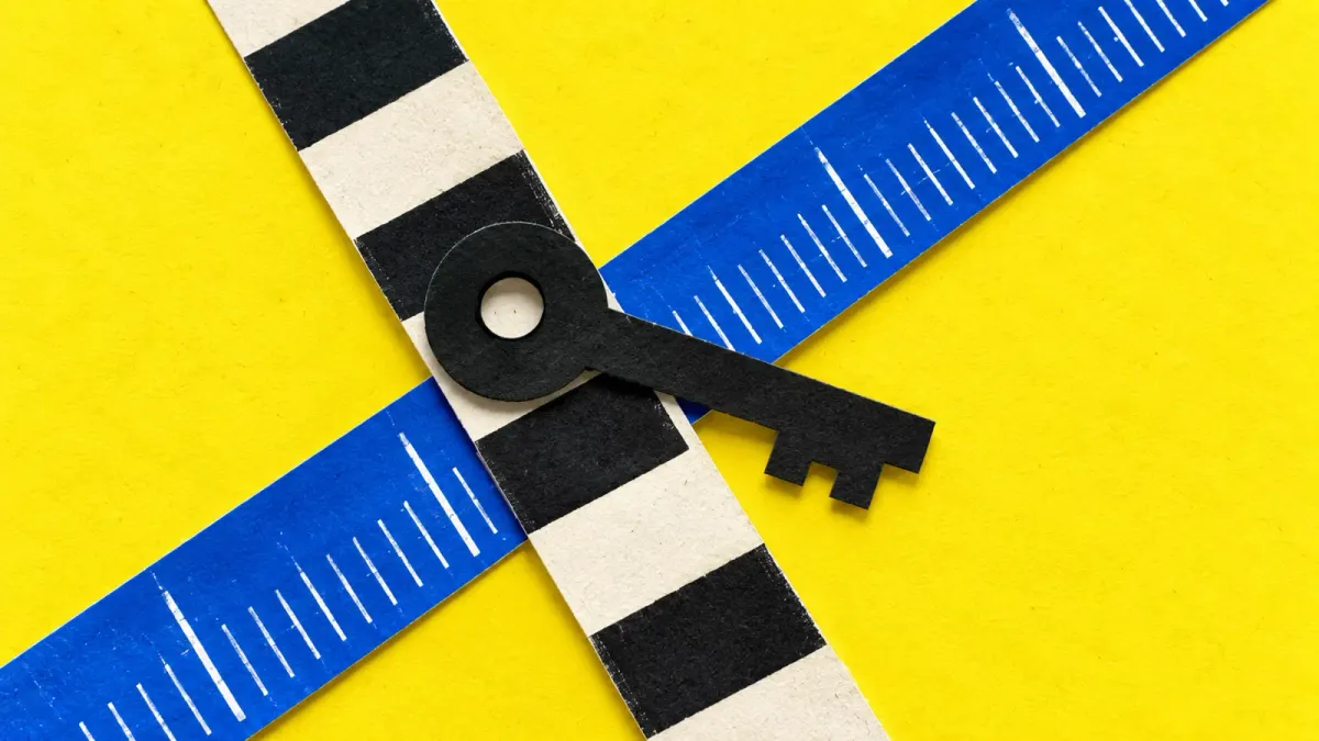 A black paper key crosses two contrasting measurement strips on a yellow and cobalt collage.