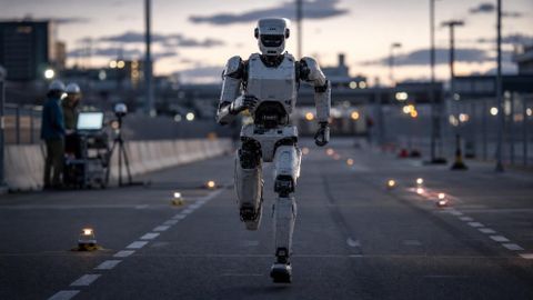 Humanoid robot running on an urban test course at dusk, symbolizing robotics reliability and autonomous deployment.