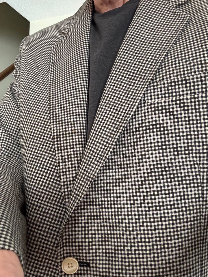 A close-up of my father’s black-and-white checkered sport jacket, worn again, showing the lapel and front button.