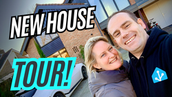 Franck & Daphne in front of new house; big letters on the image say: New House Tour. This is referencing the YouTube video embedded in this post.