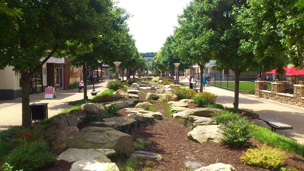 Dry creek bed with large buried boulders on the curves and mixed river cobble in the channel