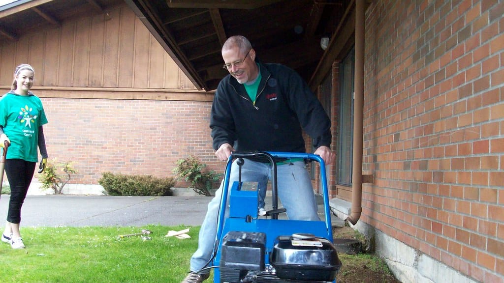 Homeowner running a sod cutter to remove lawn for a turf replacement rebate