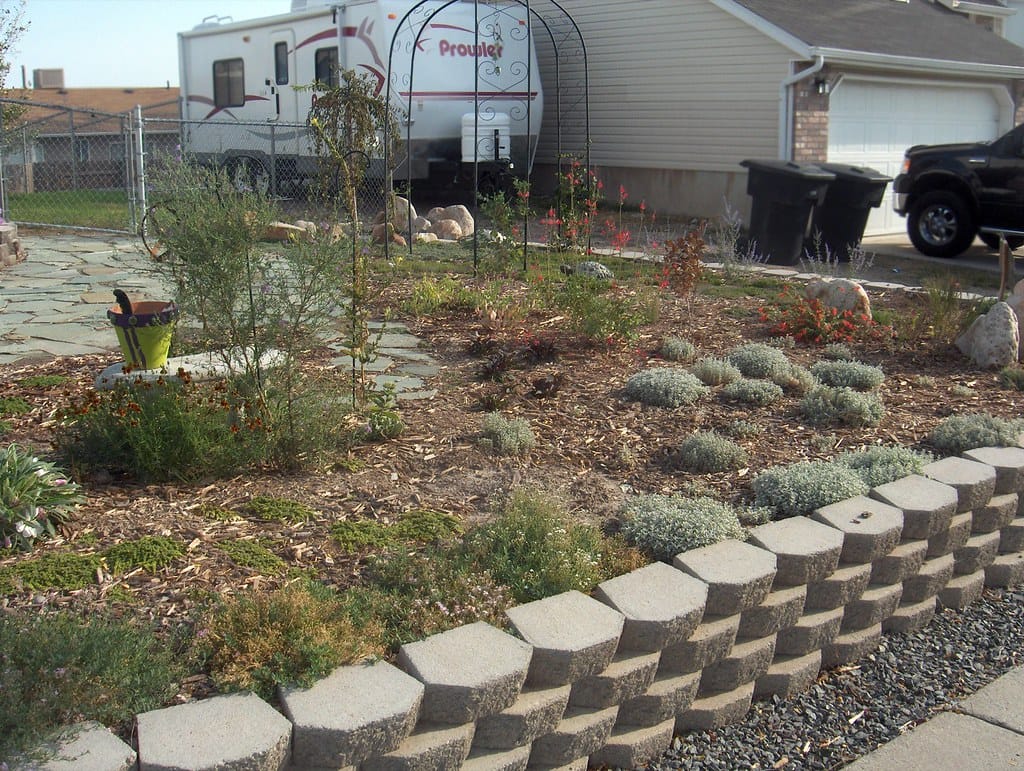 Low block retaining wall terracing a front yard slope planted with drought tolerant plants