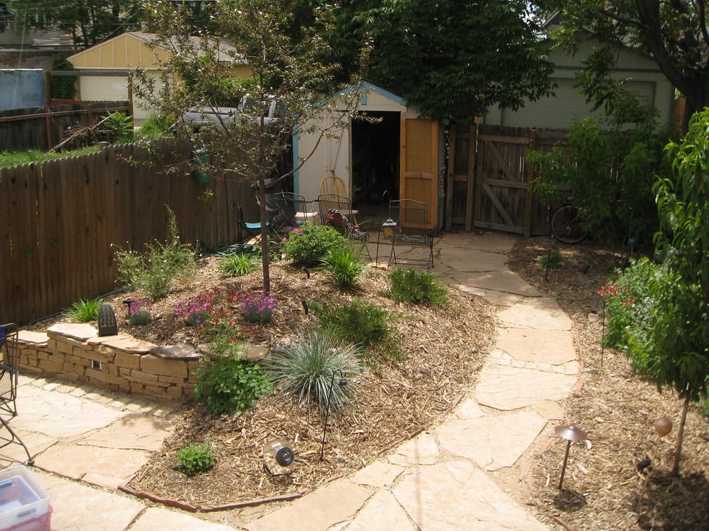 Newly planted xeriscape with small young plants spaced in fresh mulch beds