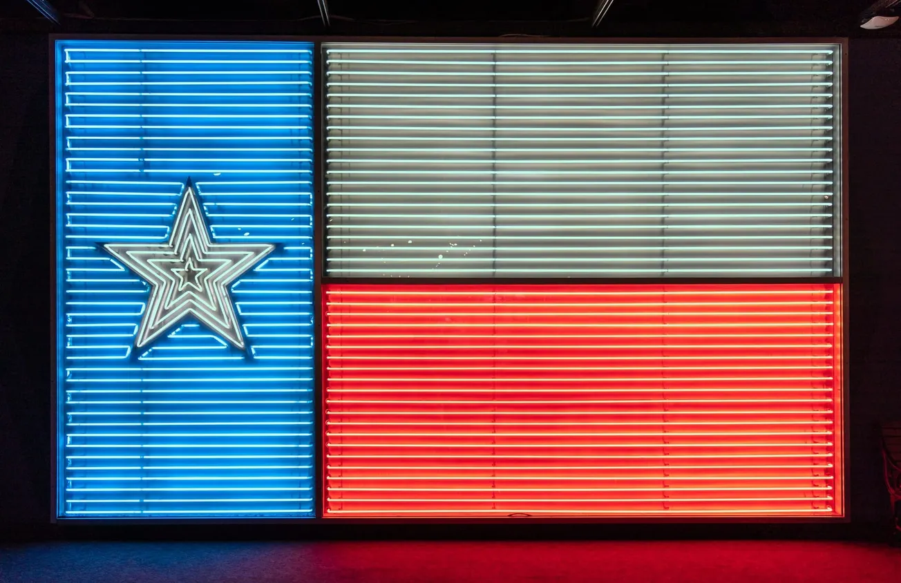 A photograph of a neon sign depicting the Texas flag.