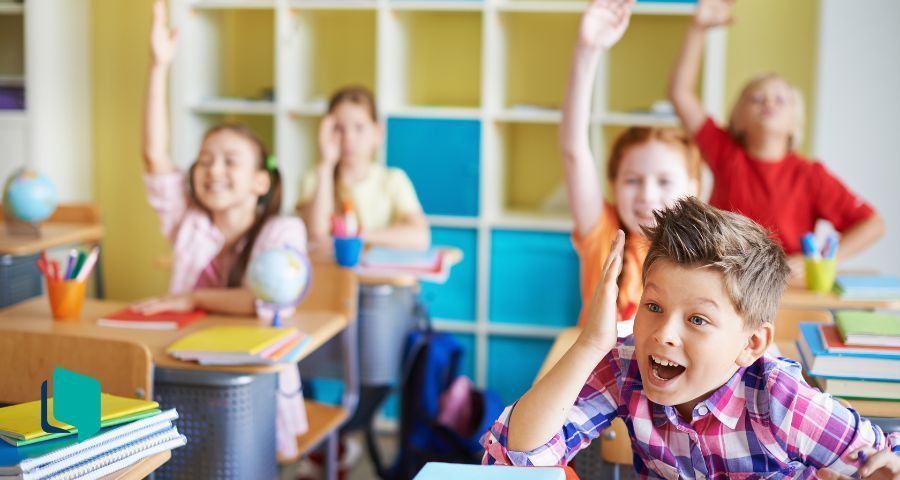 Aulas de conversação em inglês: alunos sentados com a mão erguida esperando a vez de falar
