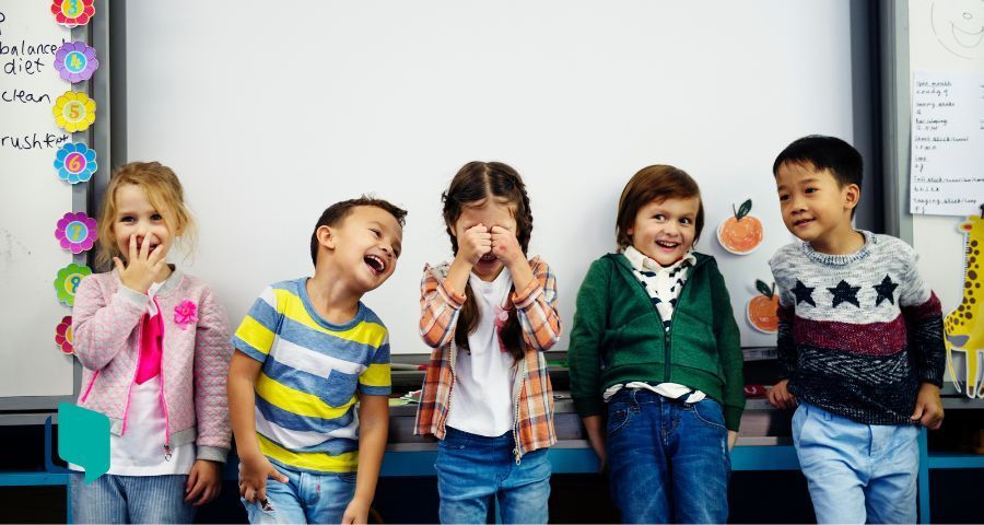 O que ensinar de inglês na educação infantil? Turma de alunos crianças em frente a um quadro