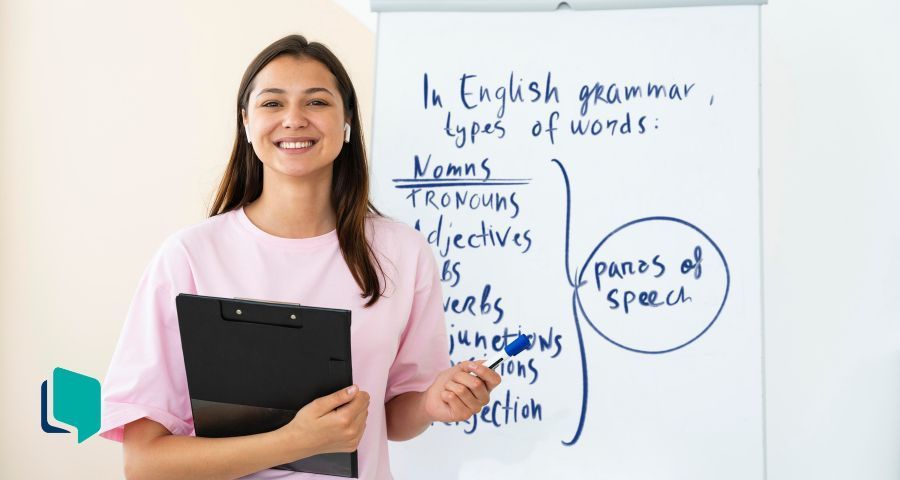 Como planejar aulas de inglês mais eficazes: professora dando aula em frente a um quadro branco