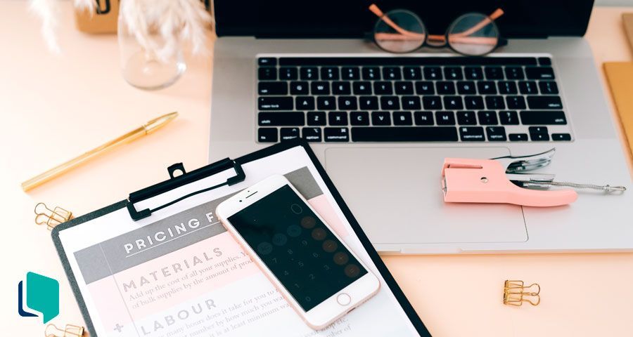 Mesa de escritório com notebook, celular e outros acessórios de trabalho