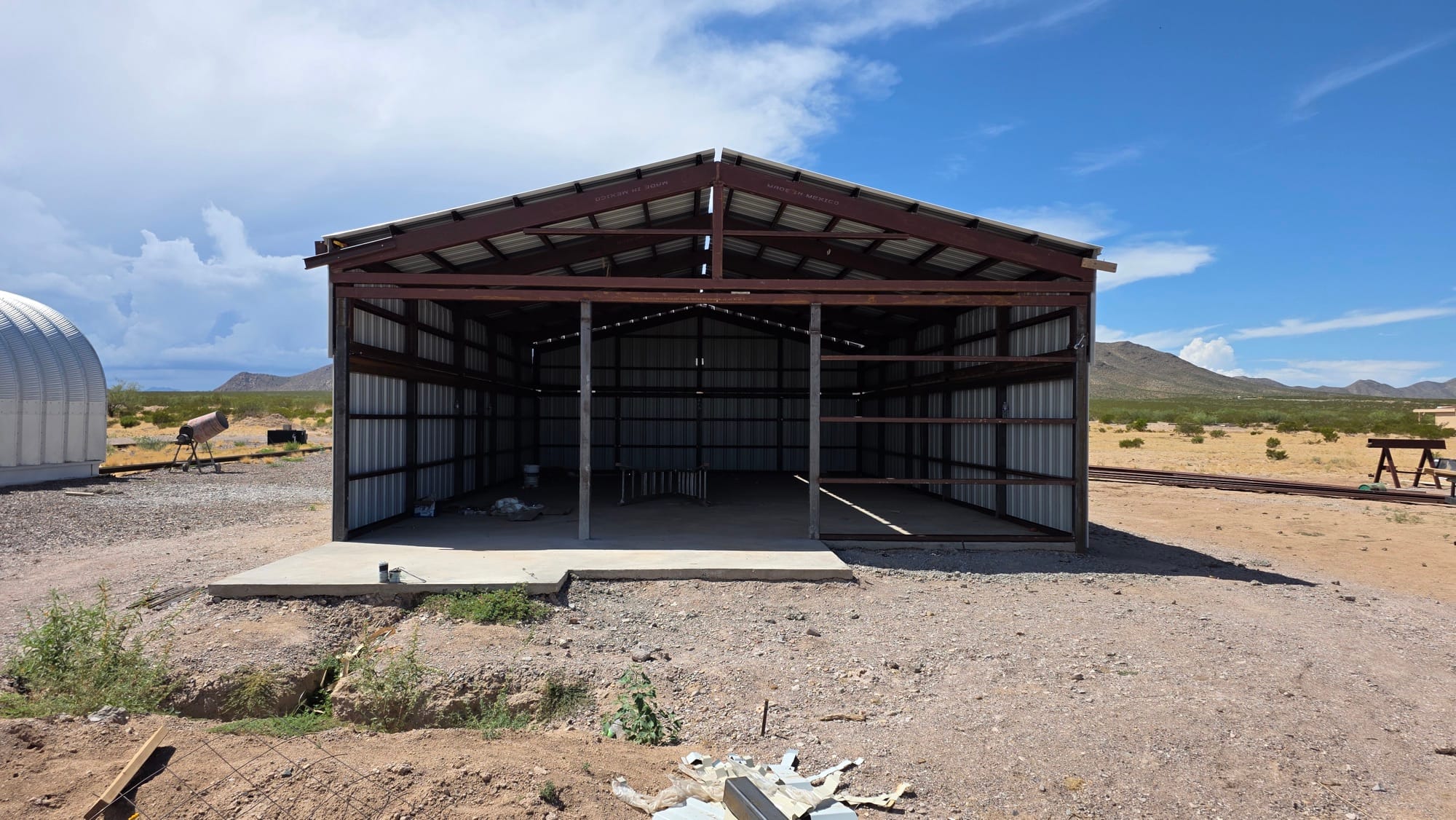 Front of Observatory 21 at DSP Remote with its open steel frame and concrete slab, the half-pipe Observatory 20 at left
