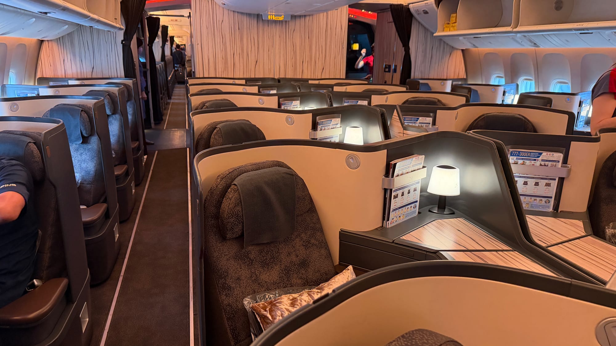 China Airlines Boeing 777 business class cabin with wood-grain walls and lit seat lamps