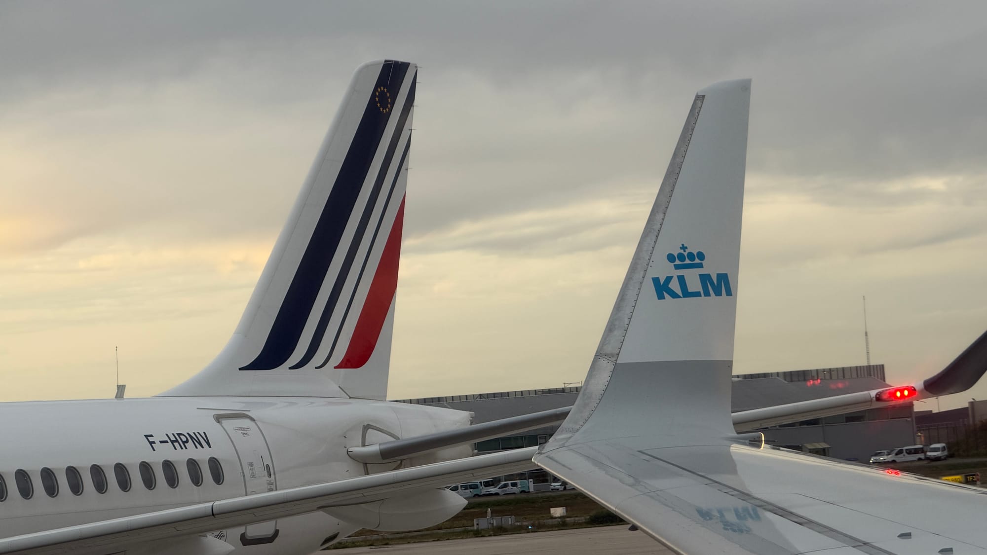 Tails of an Air France jet and a KLM jet side by side at Paris Charles de Gaulle Airport