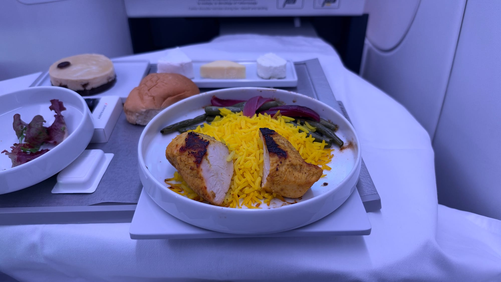 Air France business class dinner of grilled chicken with yellow rice, salad, cheese and dessert