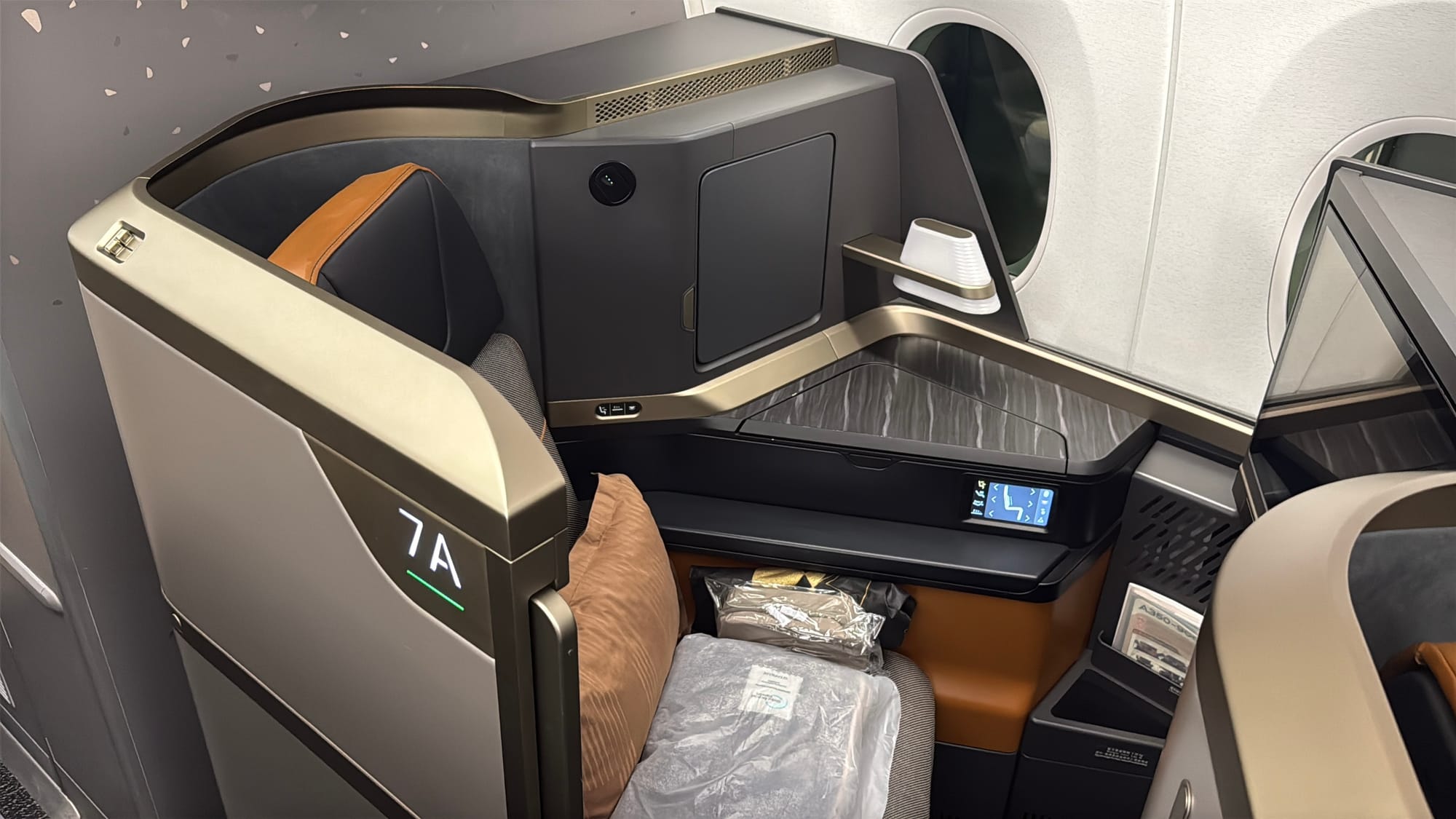 Starlux Airbus A350 business class seat 7A with a pillow and bedding wrapped in plastic
