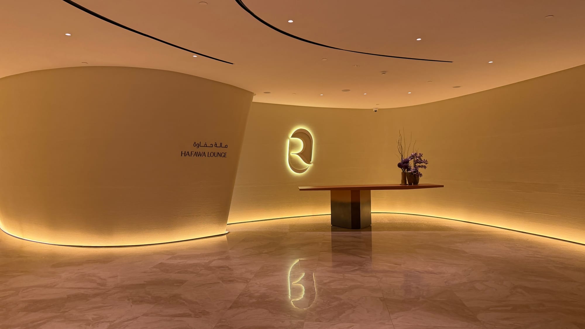 Riyadh Air Hafawa Lounge entrance with a glowing R logo and a marble floor
