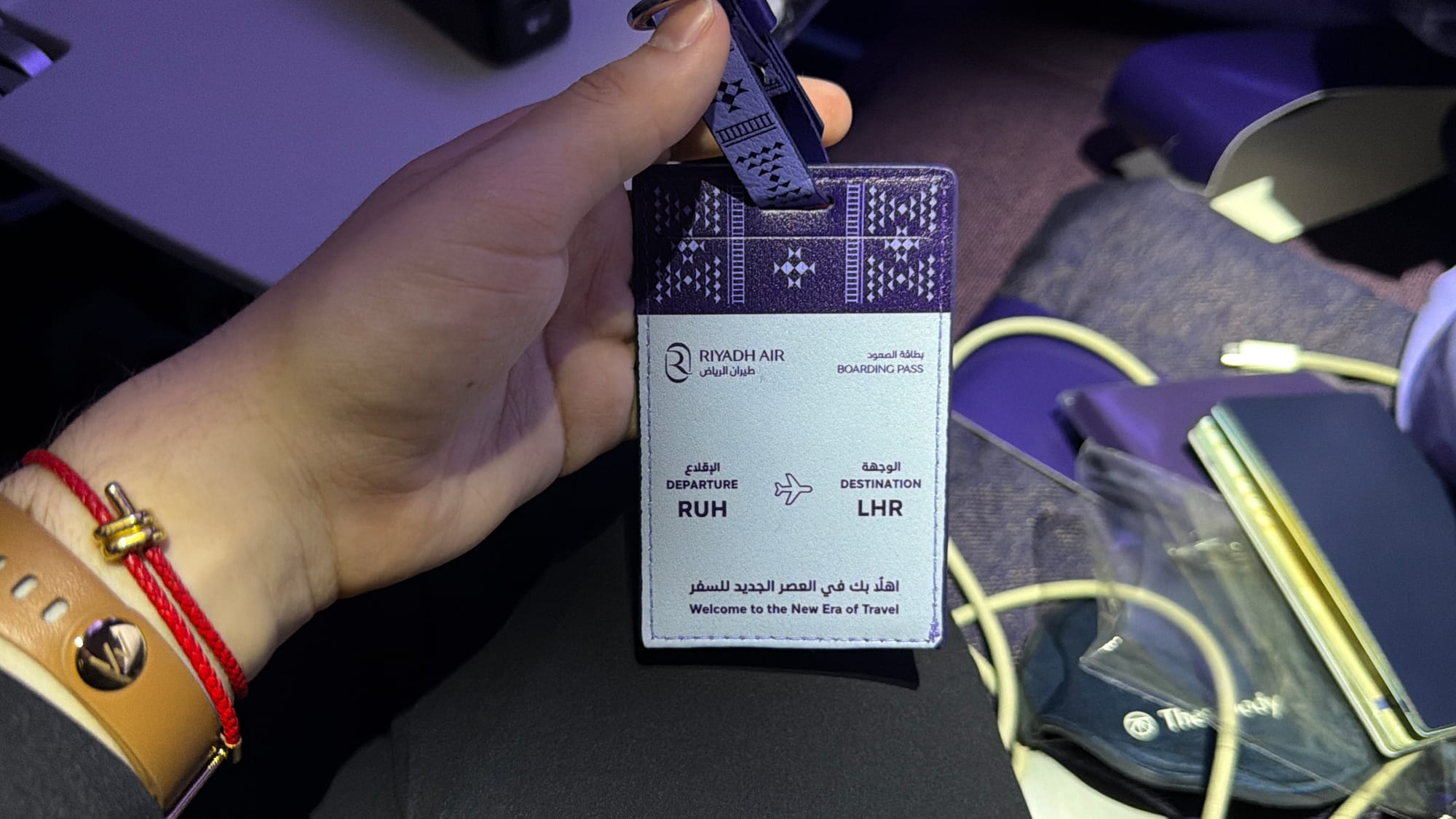 Riyadh Air commemorative boarding pass tag for the first Riyadh to London Heathrow flight, held in hand