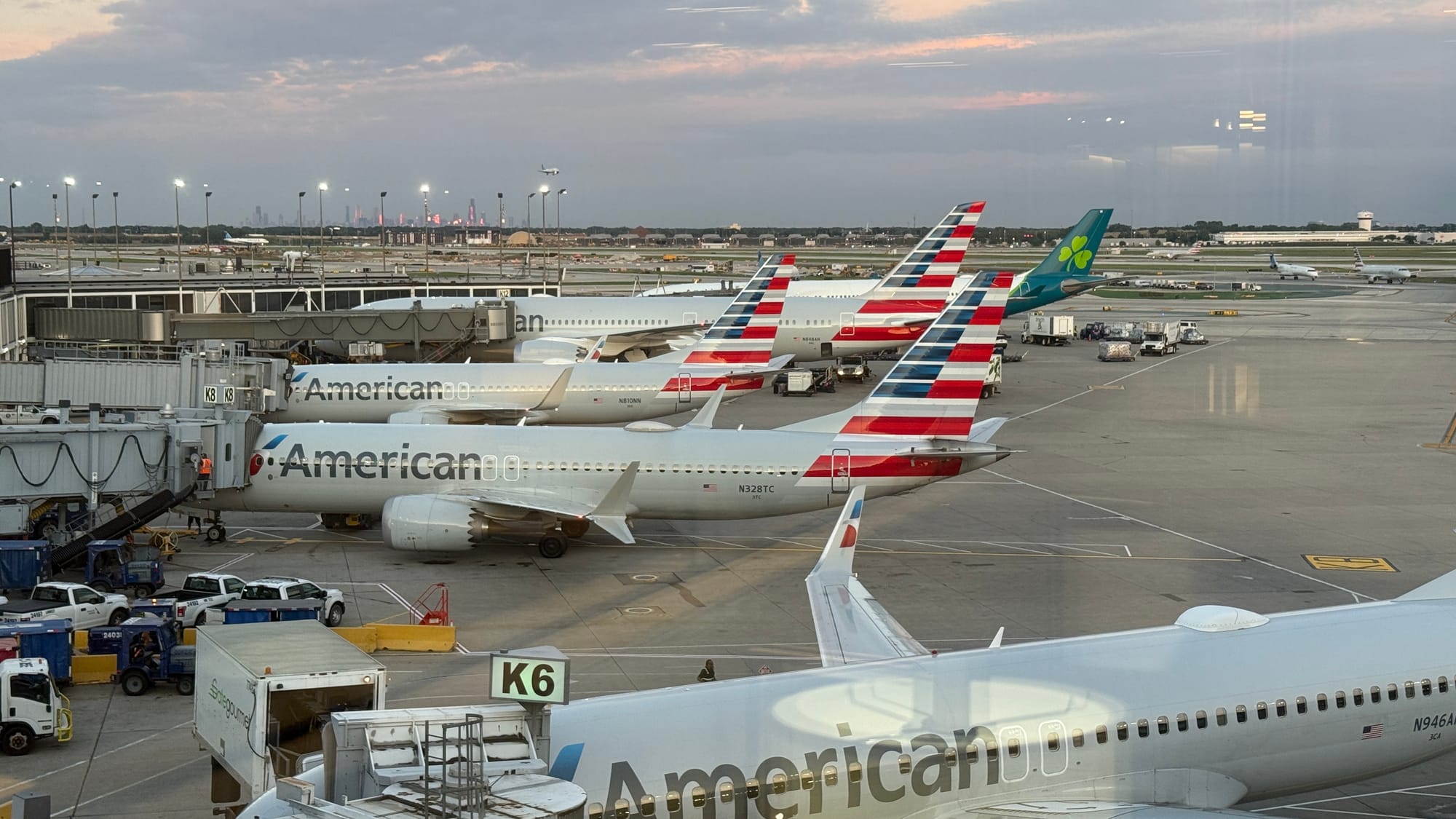 Several American Airlines jets parked at gates at Chicago O’Hare, with an Aer Lingus tail behind them