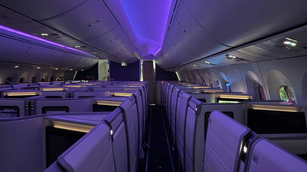 Empty Hawaiian Airlines Boeing 787 business class cabin with purple mood lighting and a starry ceiling