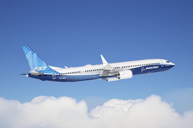 Boeing 737 MAX 10 in blue and white Boeing colors flying above clouds