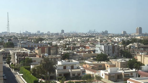 Rooftops of Jeddah, Saudi Arabia, with palm trees and the city skyline under a hazy sky