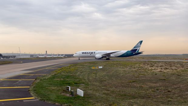 WestJet Boeing 787 taxiing at Paris Charles de Gaulle Airport under a cloudy sky