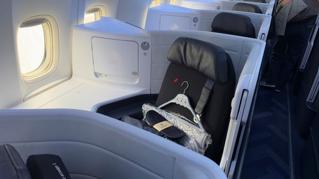 Air France A350 business class seat with a hanger, slippers and wrapped bedding waiting at the seat